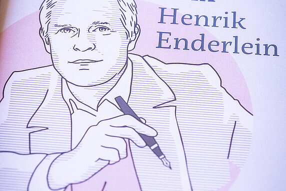 A line-art illustration depicts Henrik Enderlein holding a pen. Next to him are the words "Prix Henrik Enderlein", as well as a copy of his signature.
